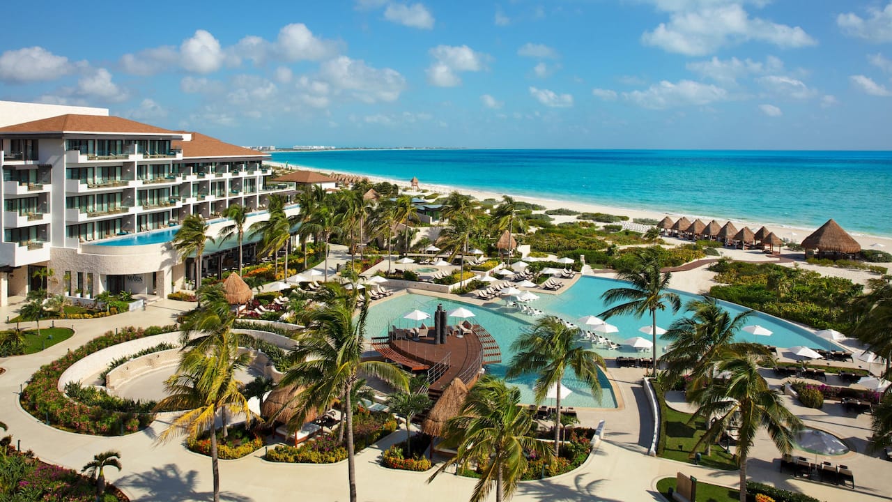 Vista panorámica de las piscinas y del mar en Dreams Playa Mujeres